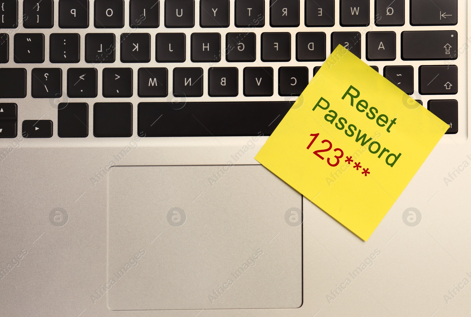 Image of Sticky note with phrase Reset Password on laptop, top view