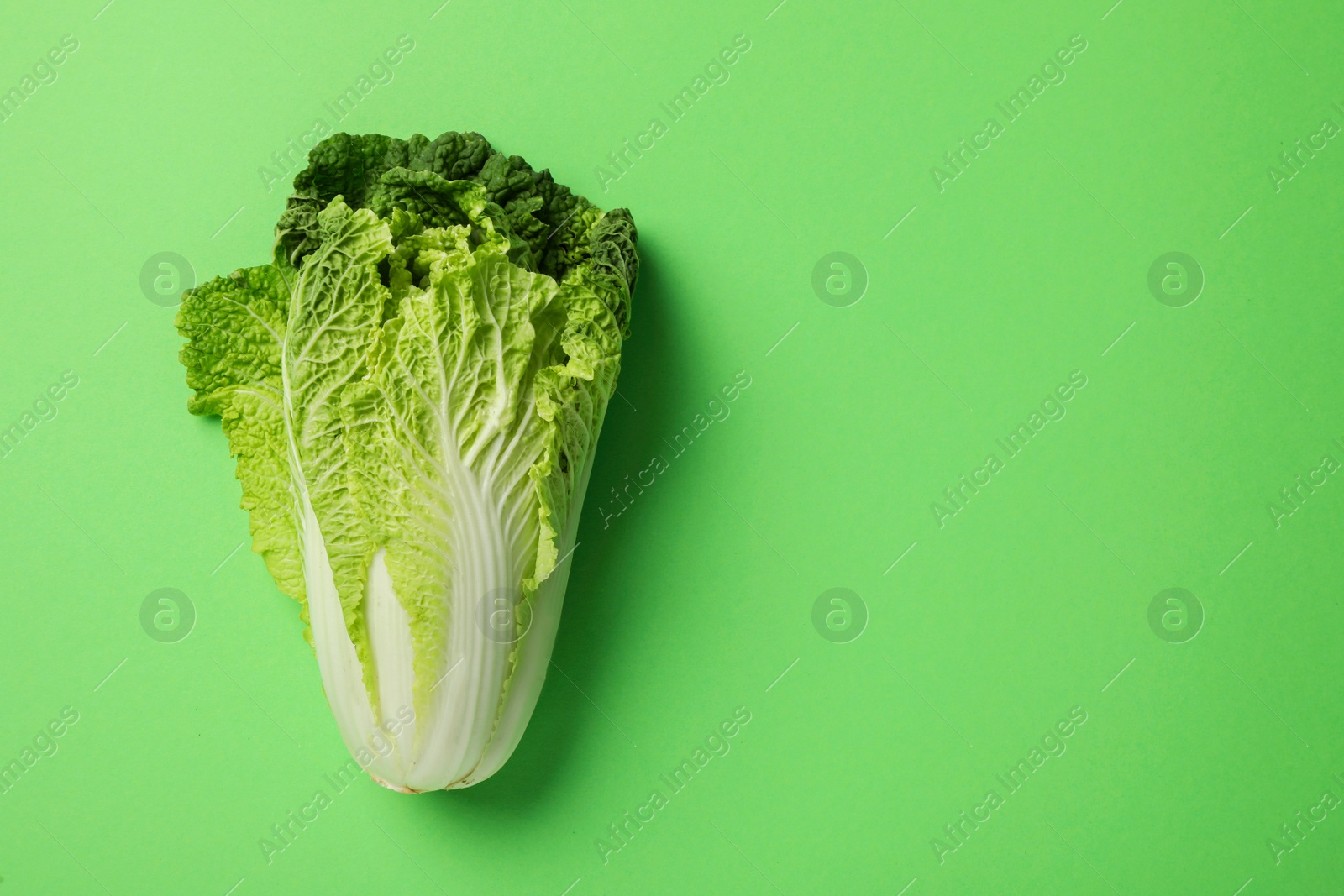 Photo of Fresh ripe Chinese cabbage on light green background, top view. Space for text
