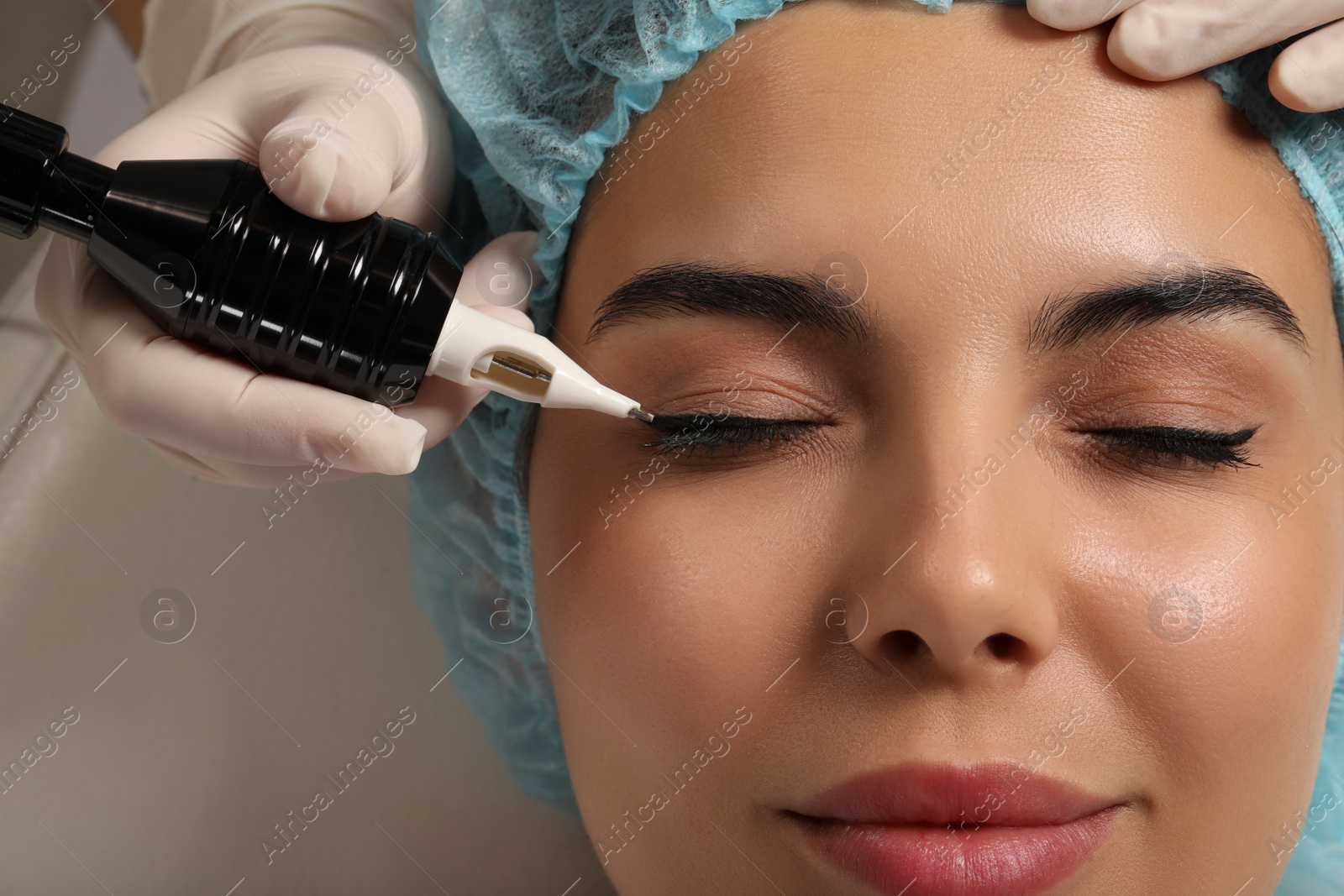 Photo of Young woman undergoing procedure of permanent eyeliner makeup, closeup