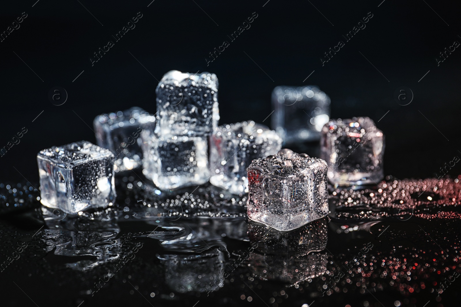 Photo of Pile of crystal clear ice cubes on black background