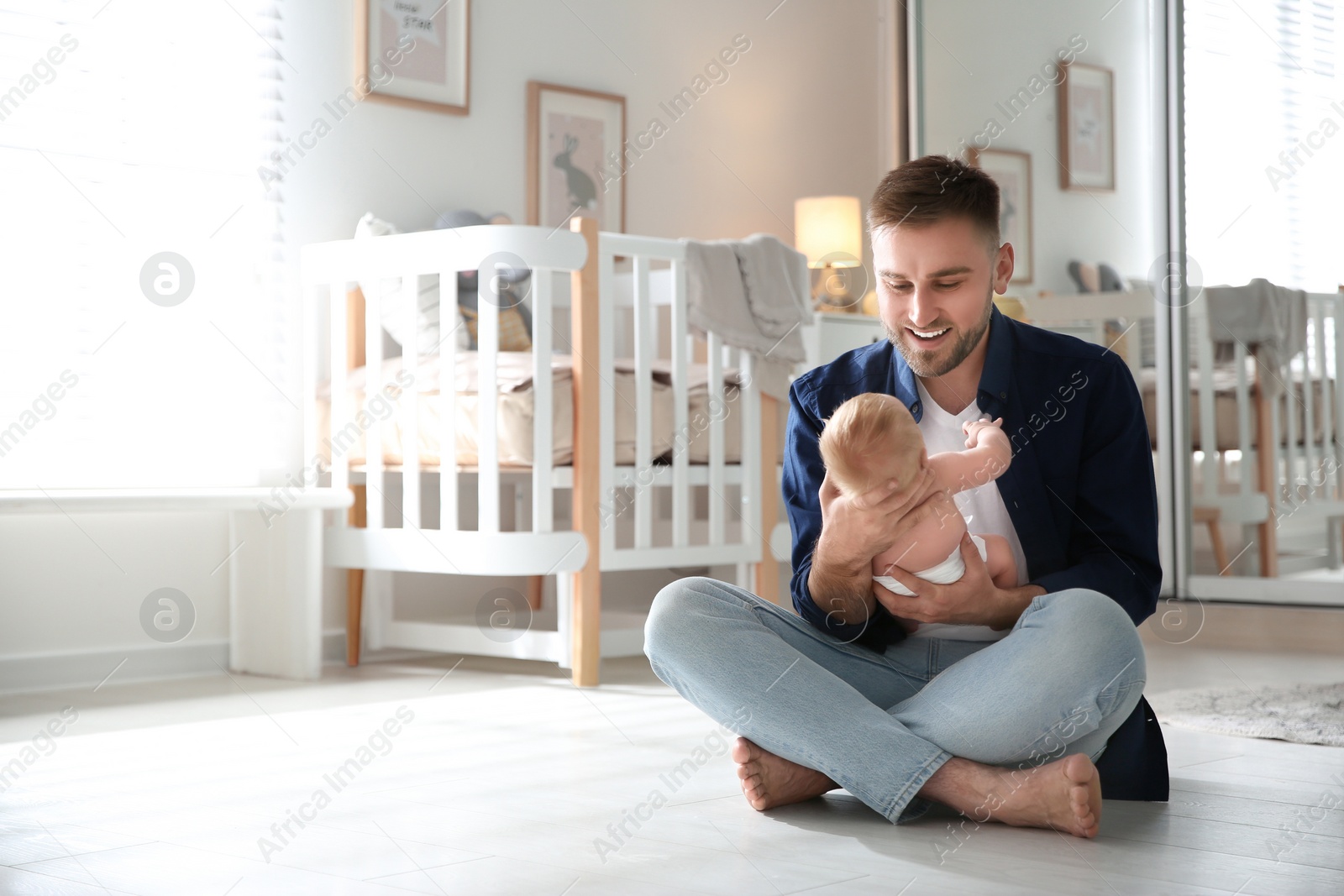 Photo of Father with his newborn son at home