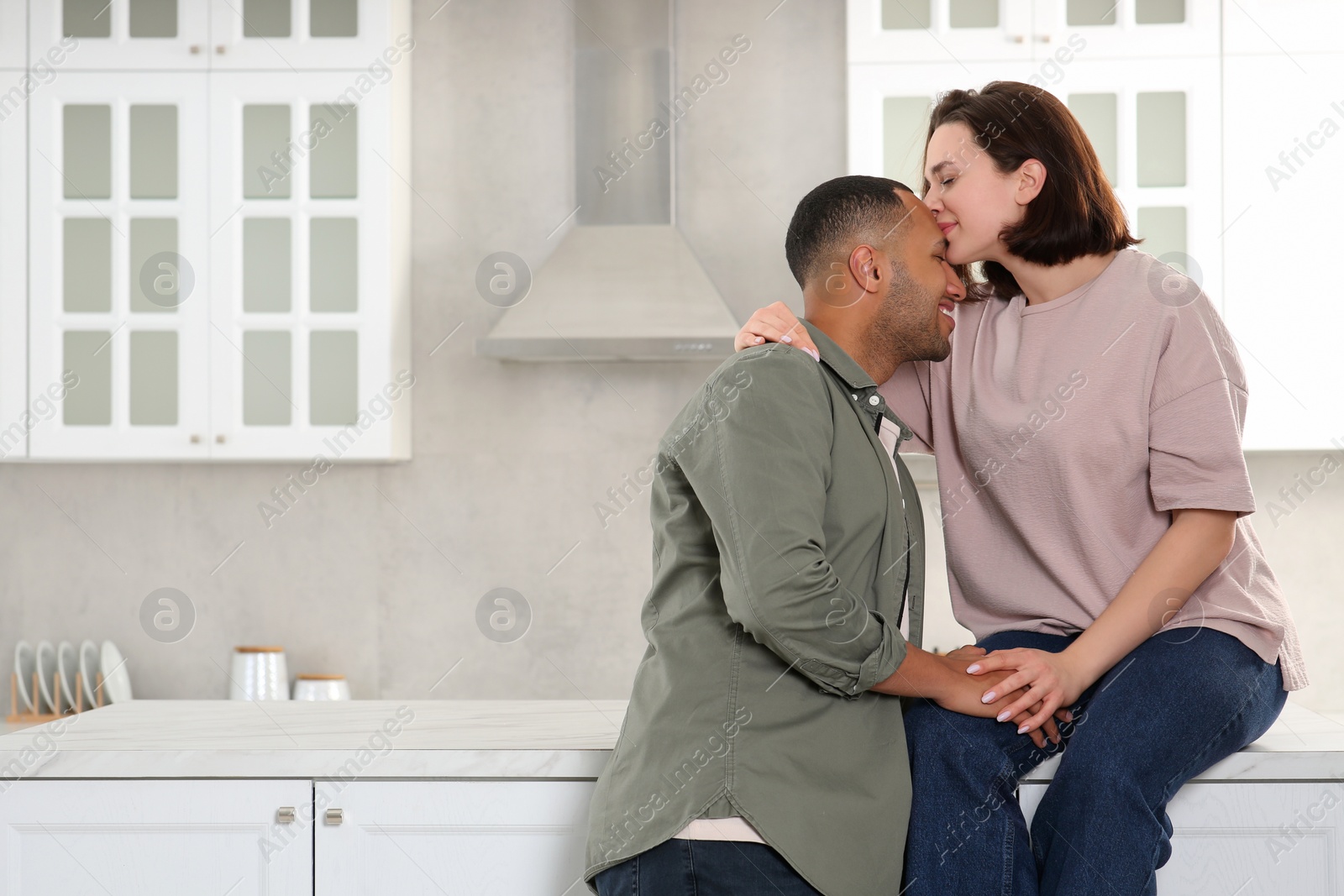 Photo of Dating agency. Happy couple spending time together in kitchen, space for text