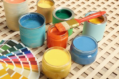 Photo of Different paints with brush and palette on wooden background