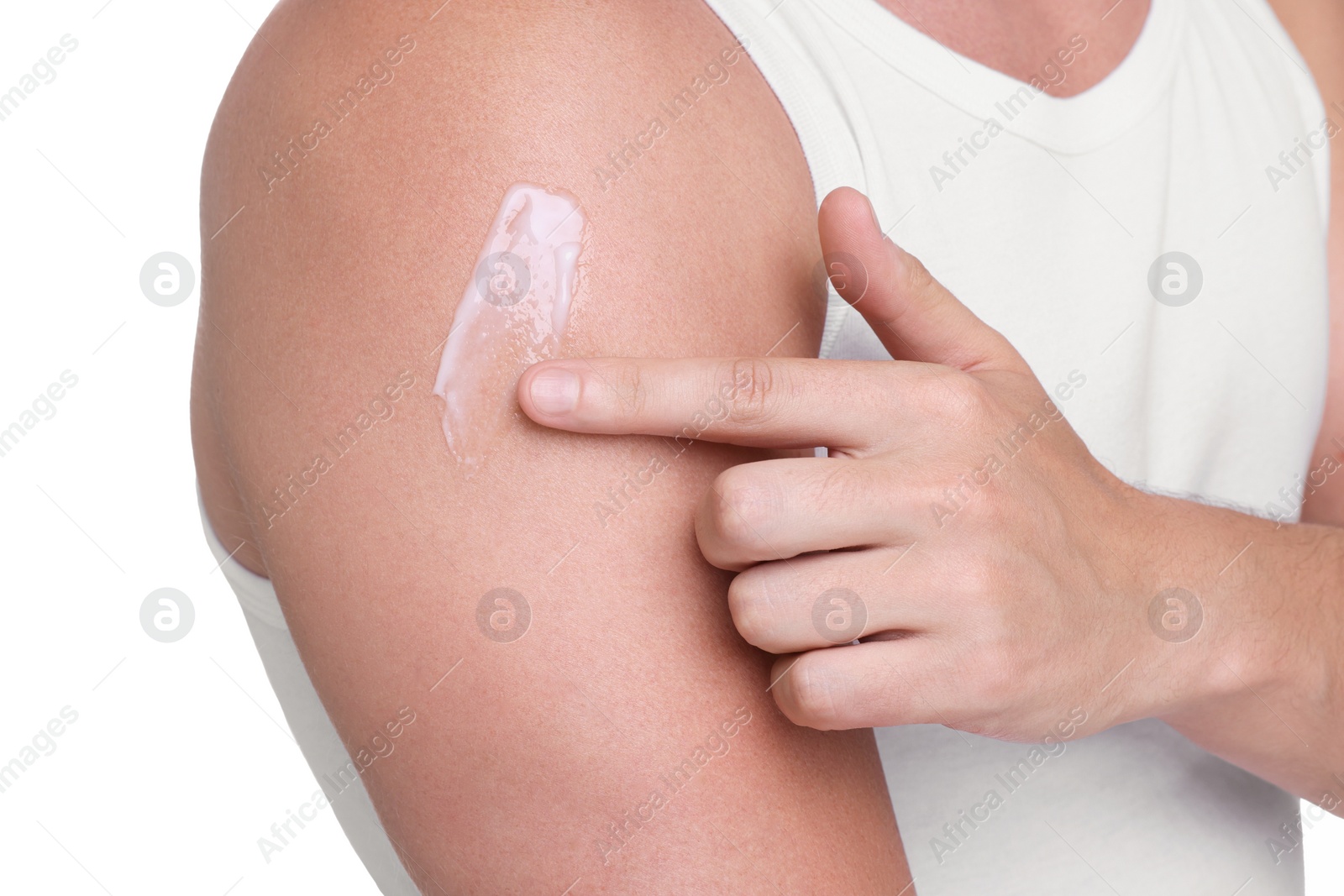 Photo of Man applying sun protection cream onto his shoulder against white background, closeup