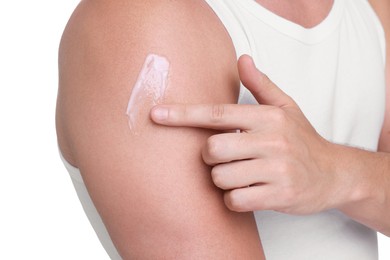 Man applying sun protection cream onto his shoulder against white background, closeup