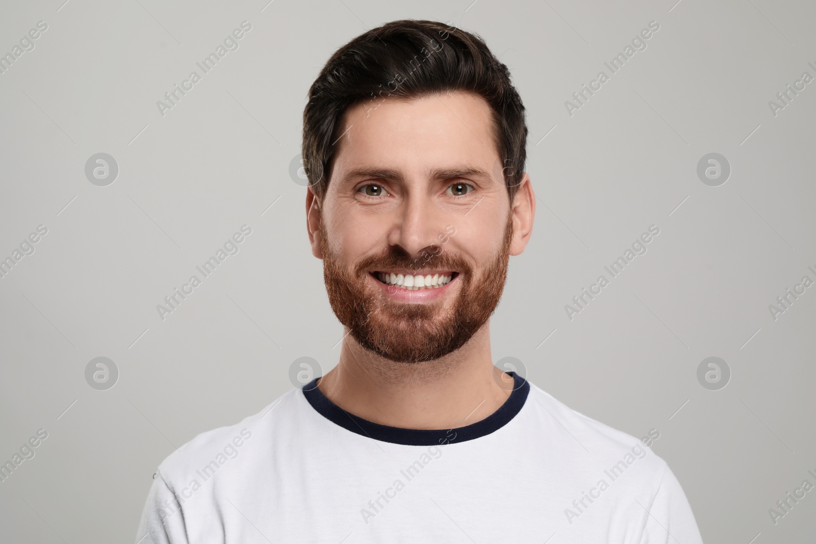 Photo of Portrait of smiling man with healthy clean teeth on light grey background