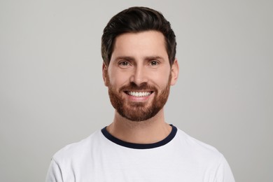 Photo of Portrait of smiling man with healthy clean teeth on light grey background