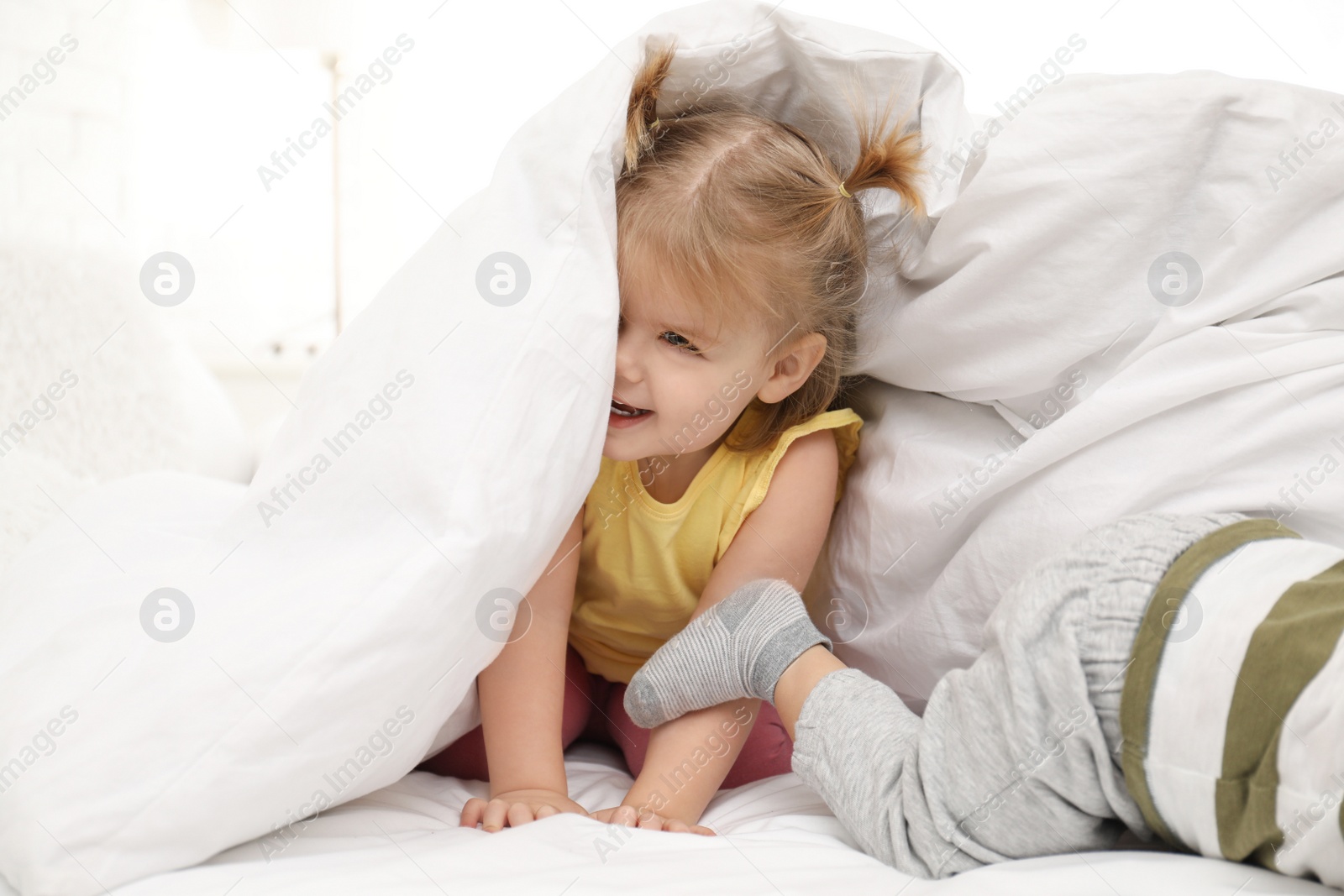 Photo of Cute little children playing together in bed