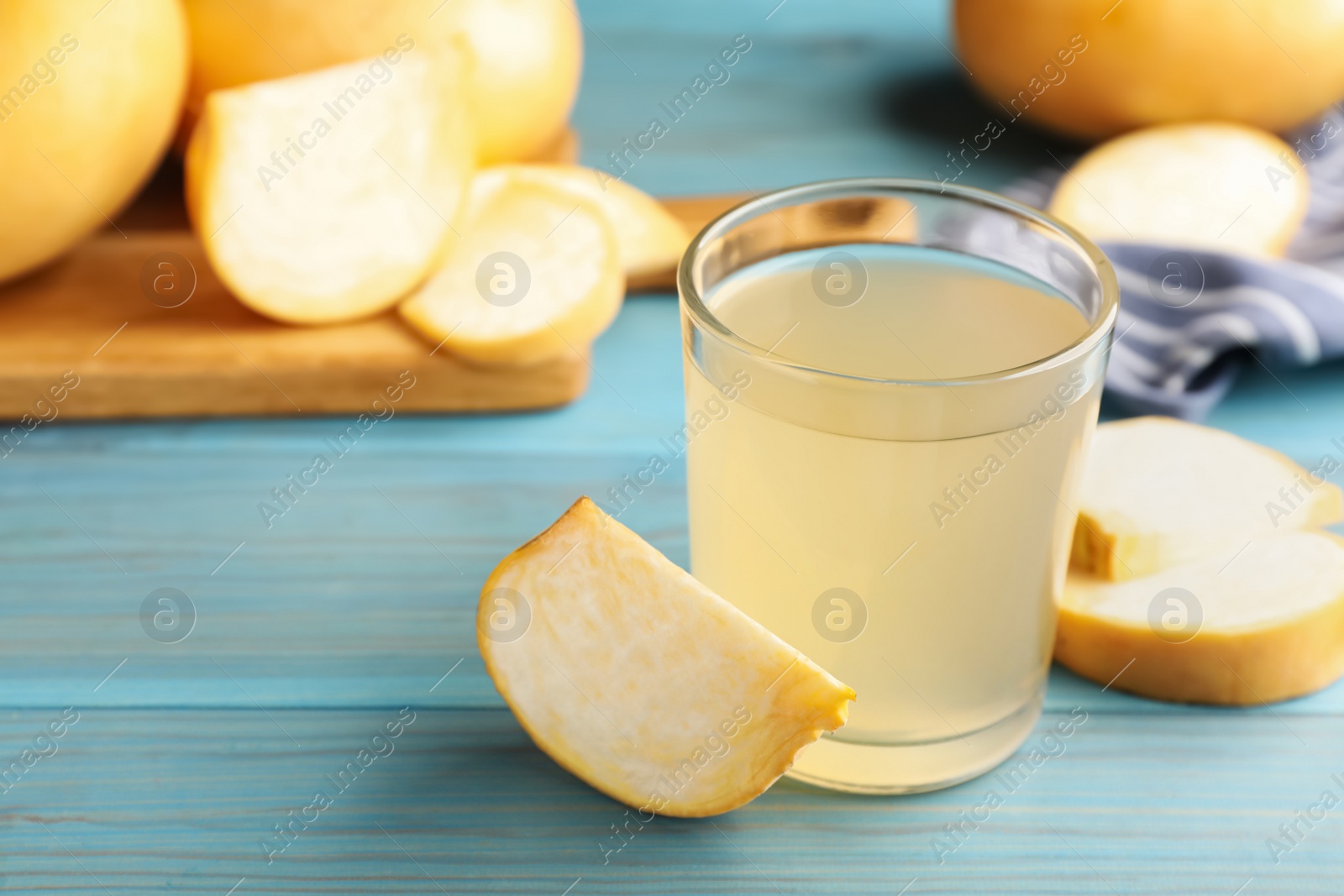 Photo of Glass of freshly made turnip juice on turquoise wooden table. Space for text