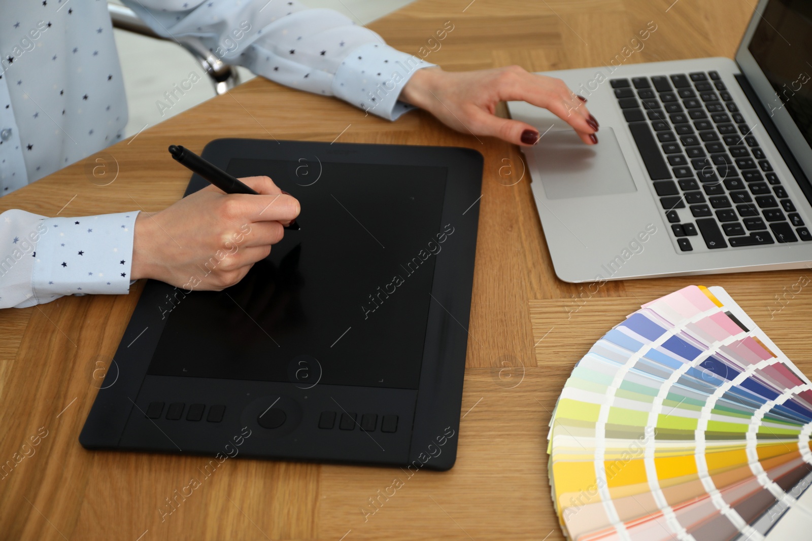 Photo of Professional designer with graphic tablet at wooden table, closeup