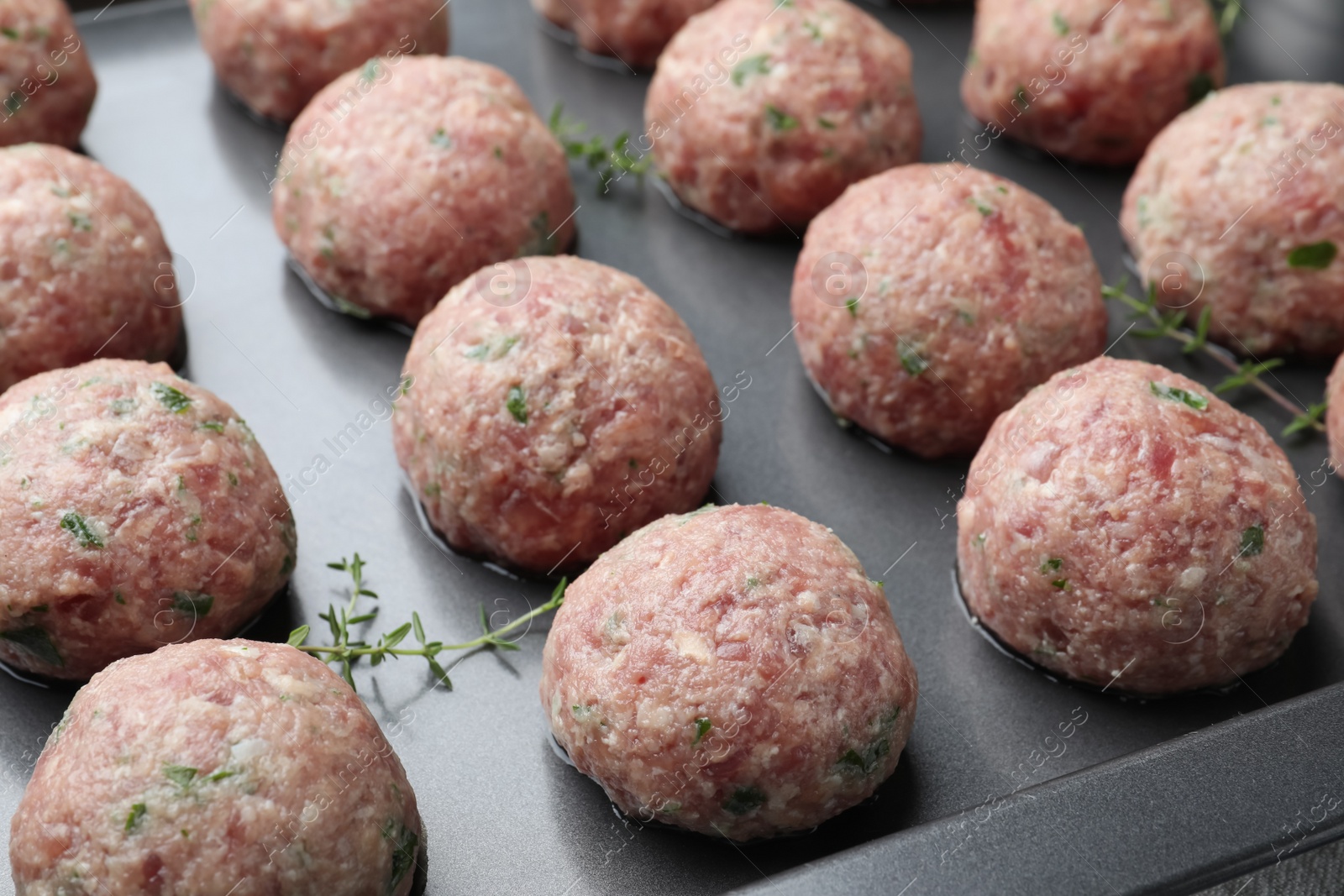 Photo of Many fresh raw meatballs in baking dish, closeup