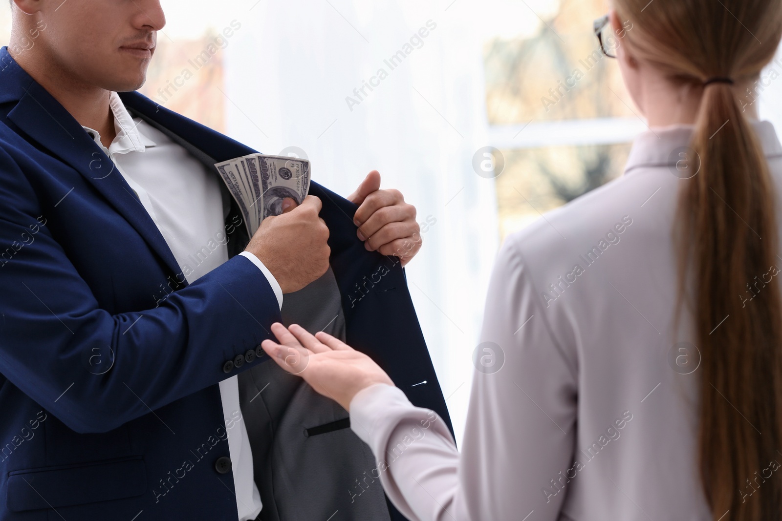 Photo of Man giving bribe money to woman, closeup