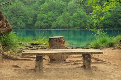 Photo of Wooden bench and picturesque view of beautiful lake
