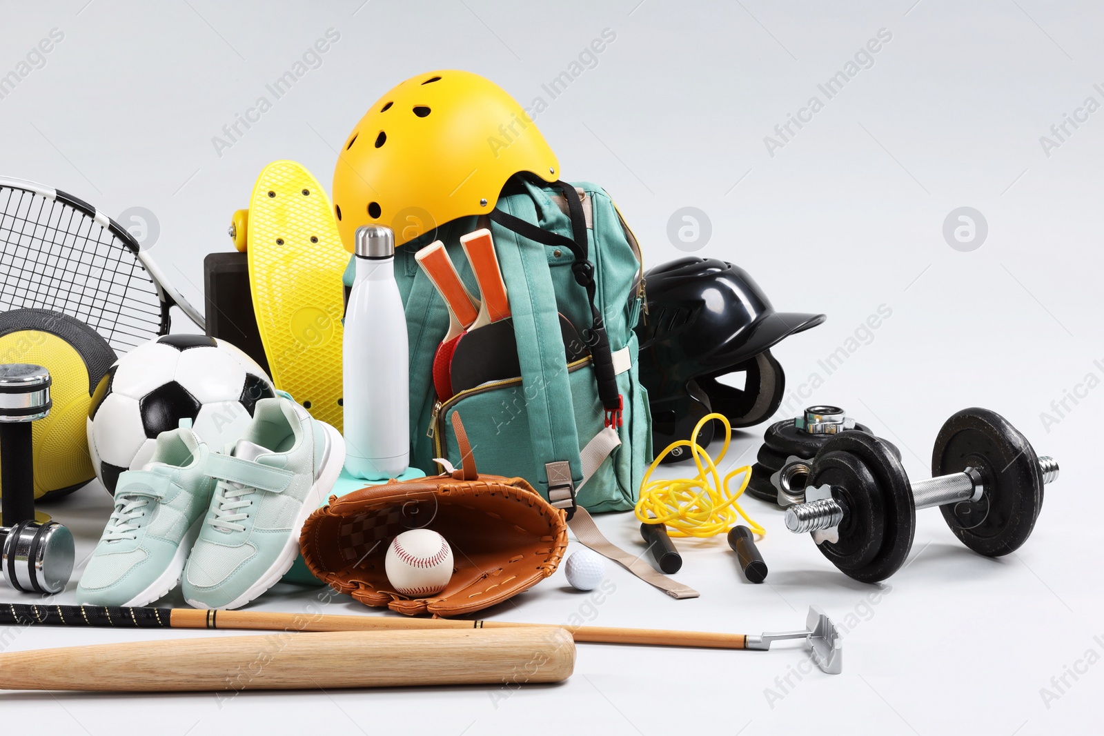 Photo of Many different sports equipment on light grey background