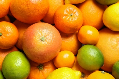 Photo of Different citrus fruits as background, top view