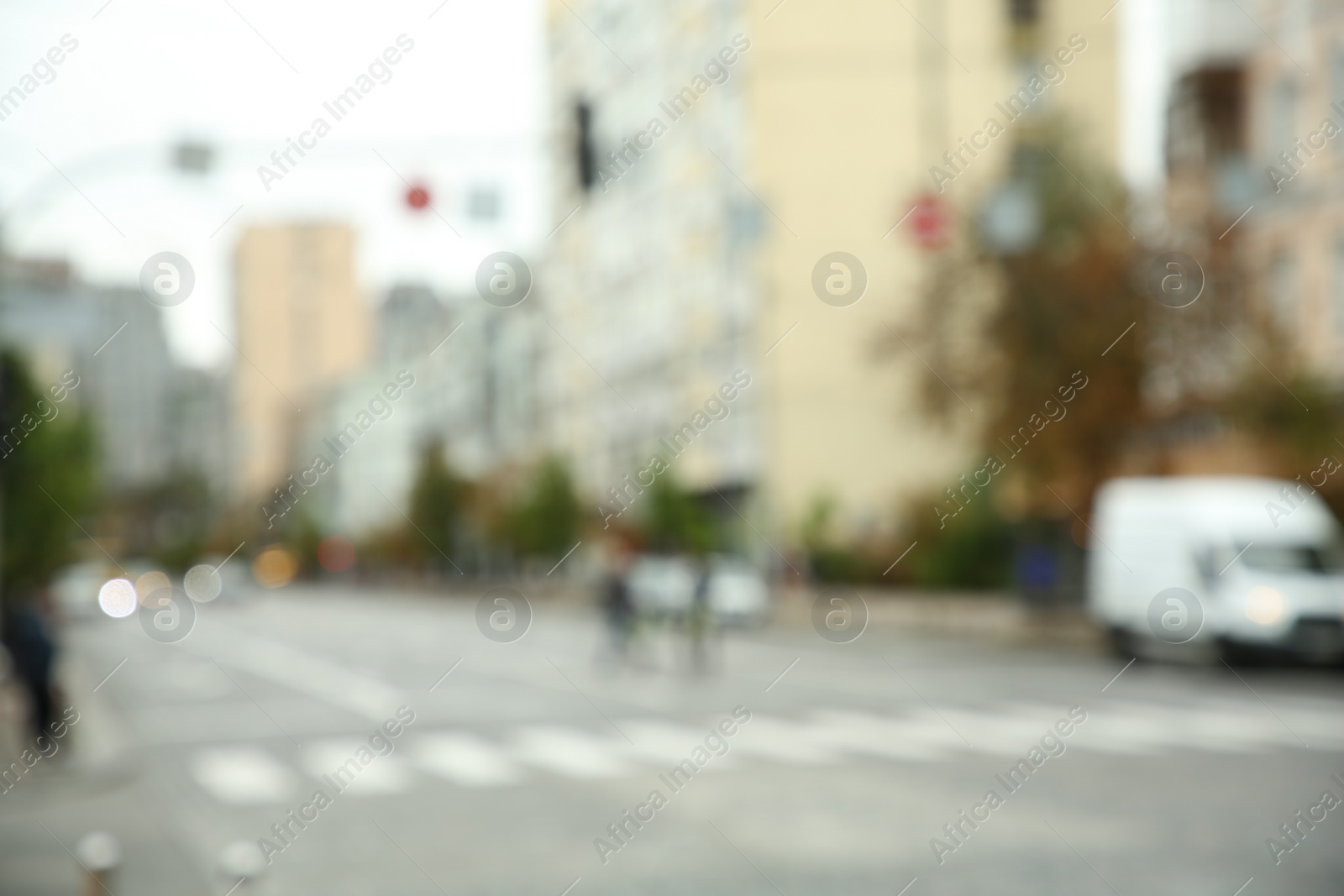 Photo of Blurred view of quiet city with buildings and cars on road