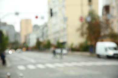 Blurred view of quiet city with buildings and cars on road