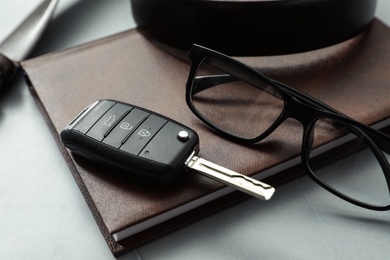 Composition with male accessories and car key on grey background