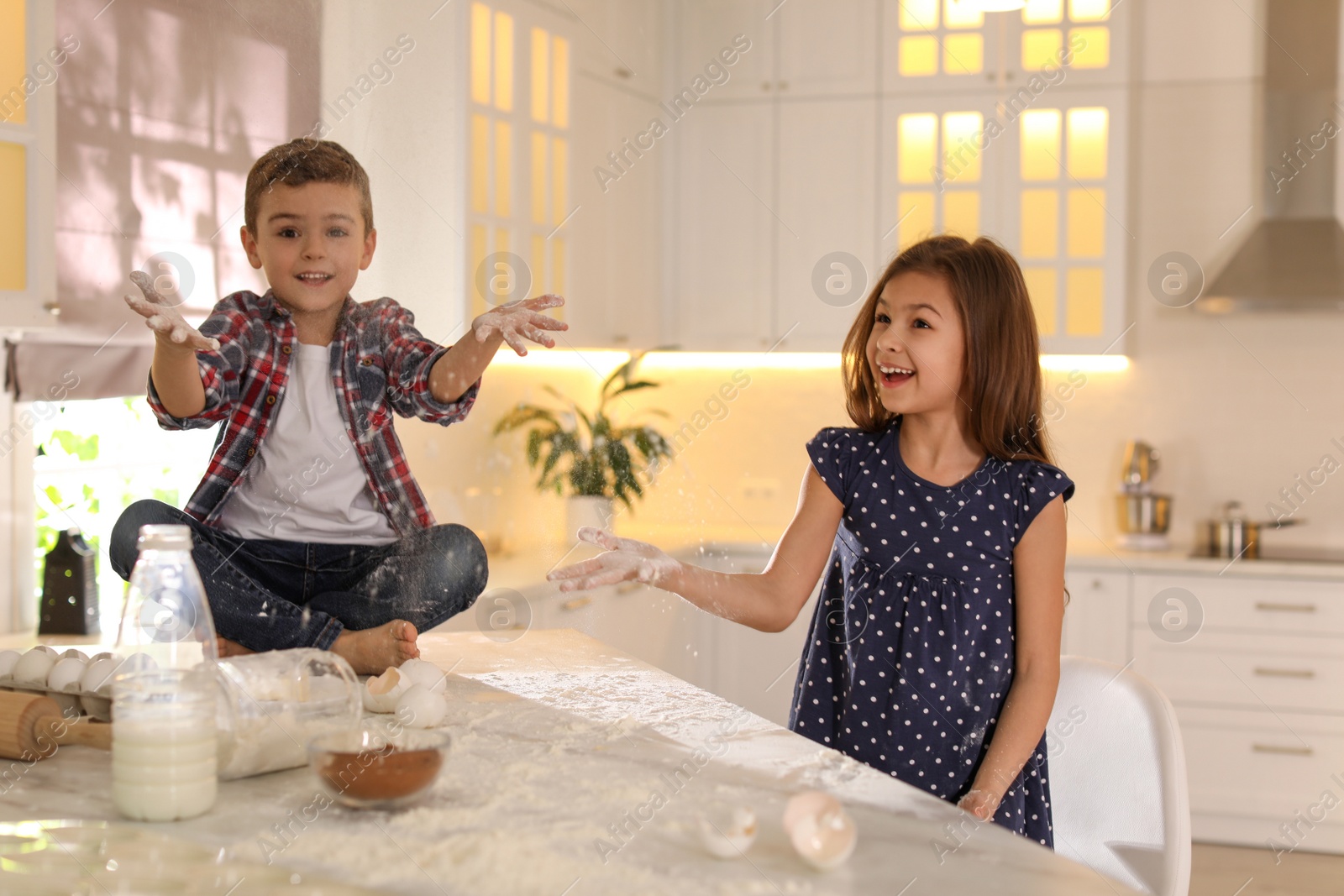 Photo of Cute little children having fun in kitchen. Cooking dough