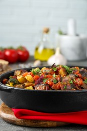 Photo of Dish with tasty ratatouille on grey textured table, closeup