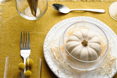 Photo of Autumn place setting with pumpkin on table, closeup view