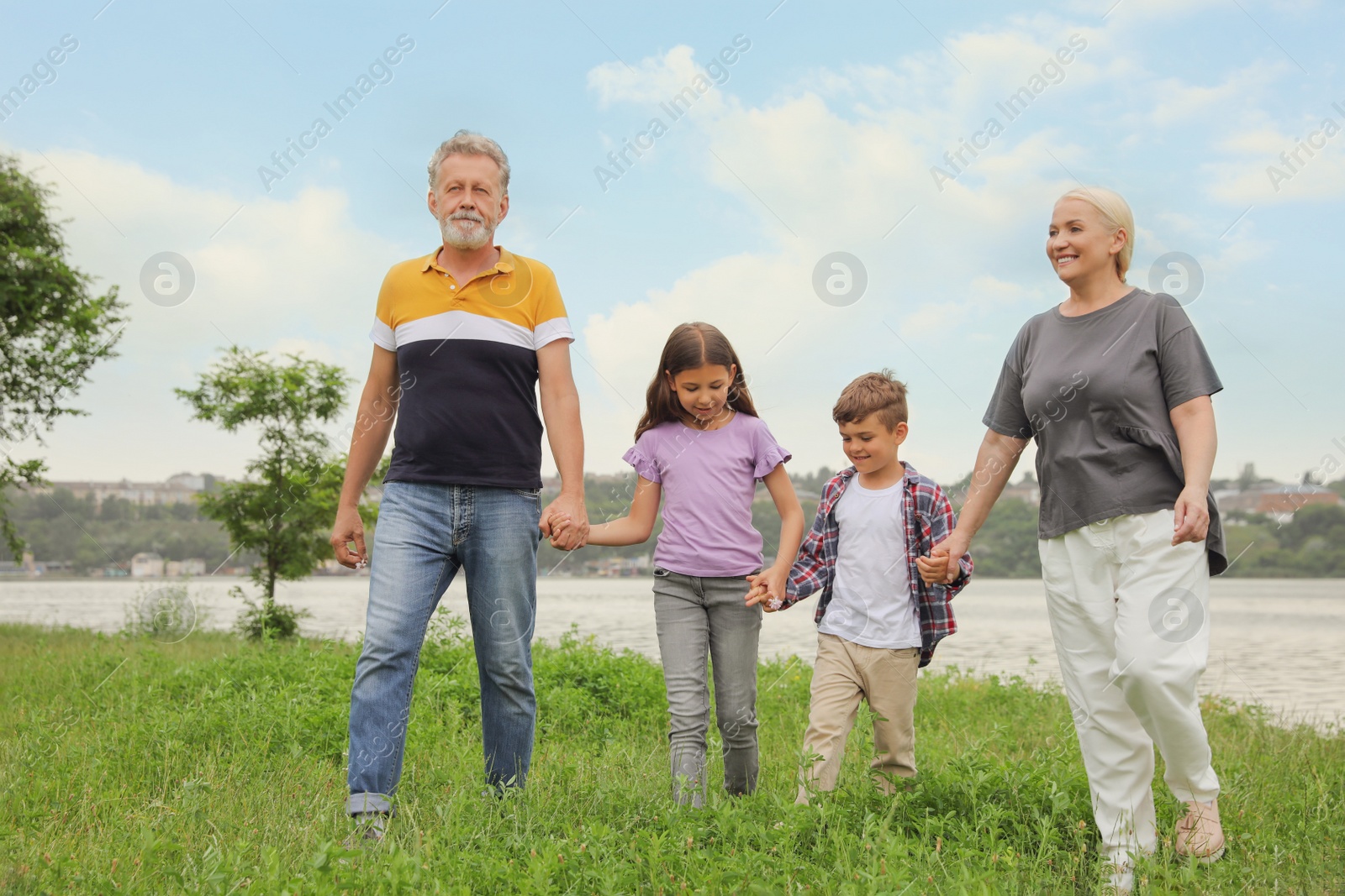 Photo of Cute children with grandparents walking in park