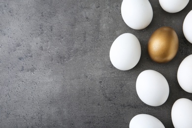Photo of Flat lay composition with golden egg and others on grey background. Space for text