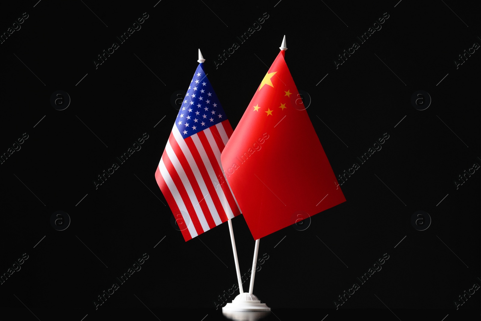 Photo of USA and China flags against black background. International relations