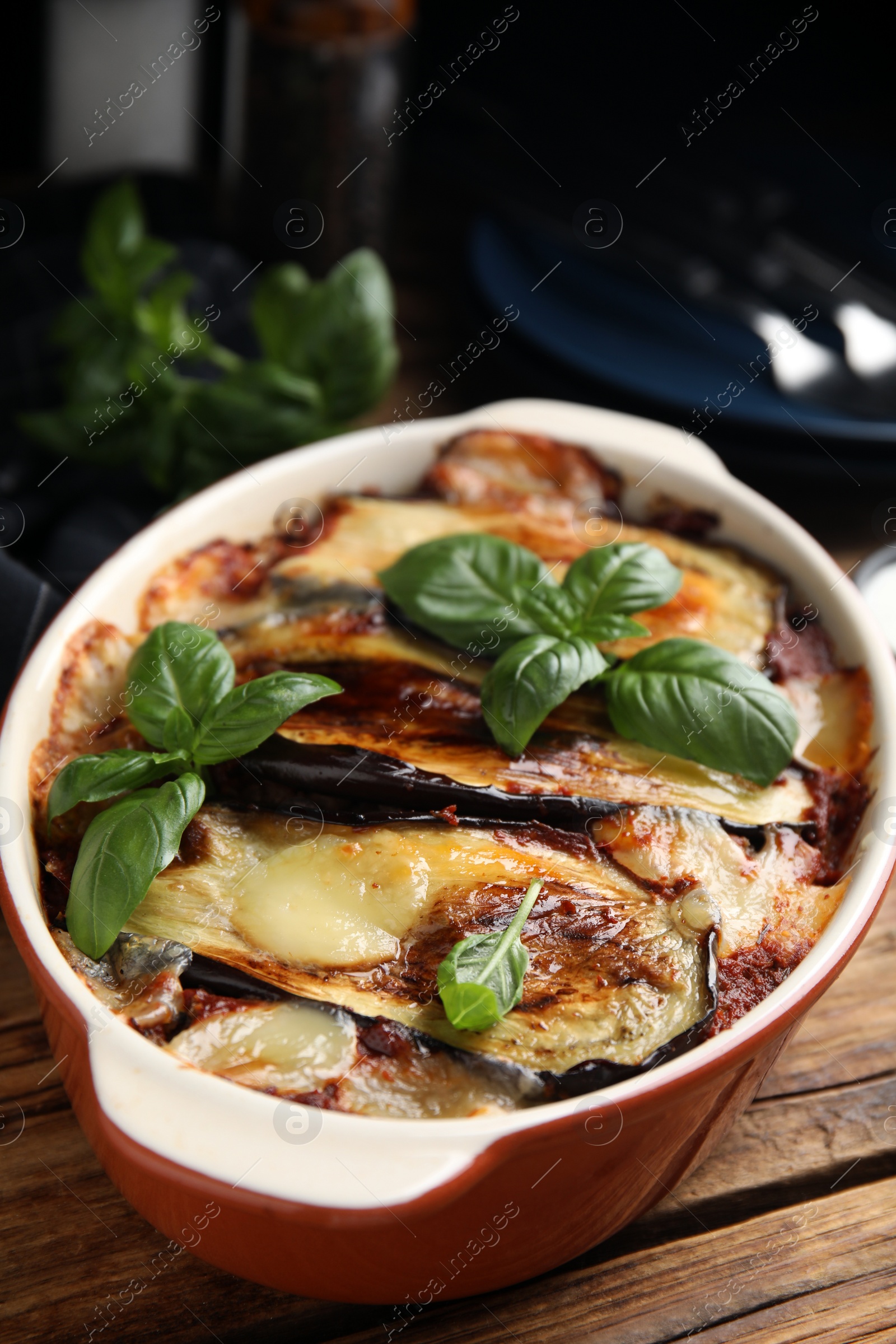 Photo of Delicious eggplant lasagna in baking dish on wooden table