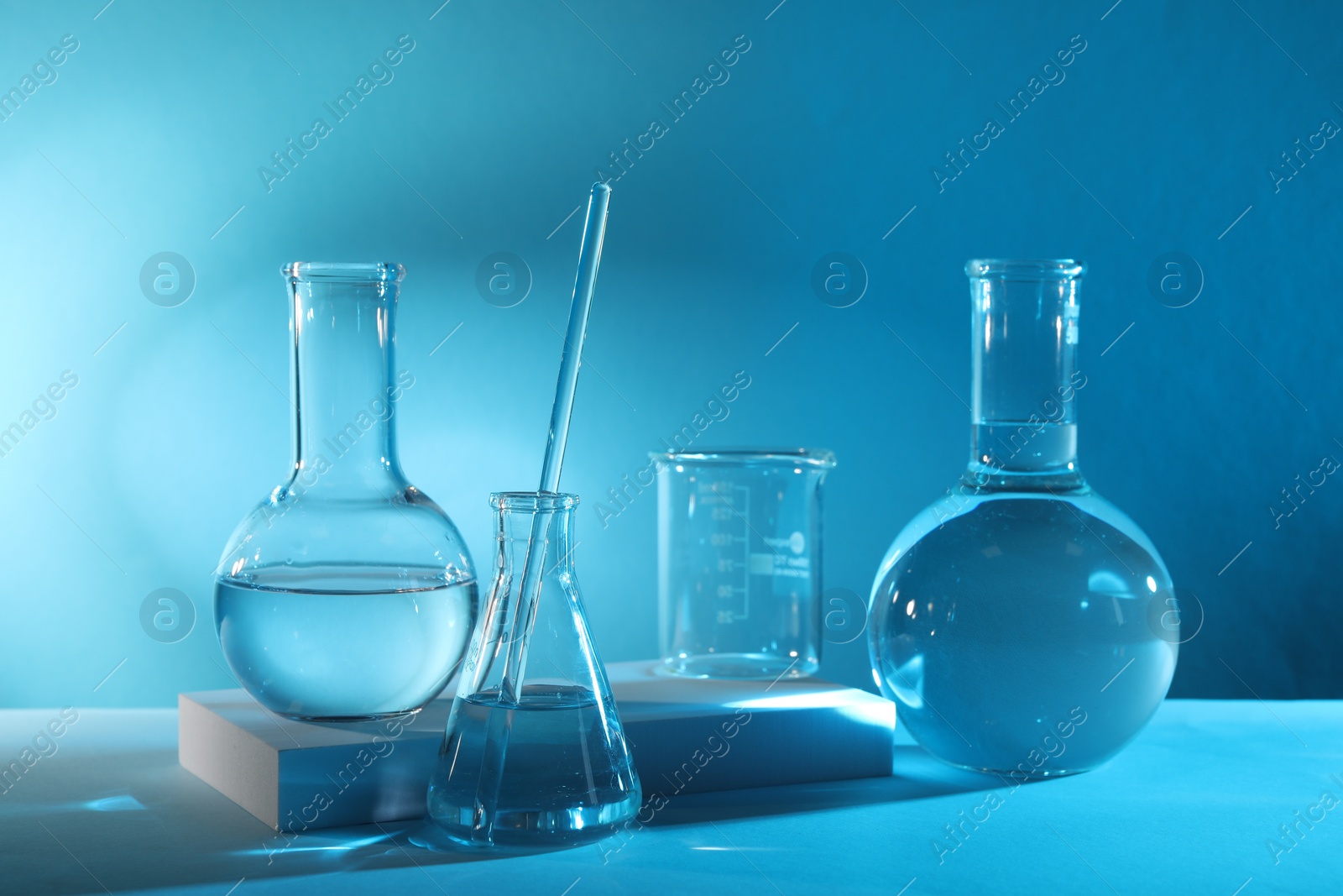 Photo of Laboratory analysis. Different glassware on table against light blue background