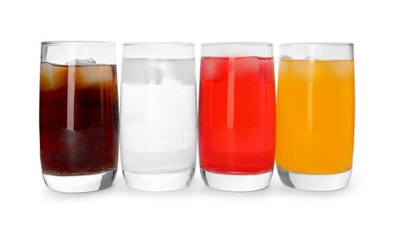 Glasses of different refreshing soda water with ice cubes on white background