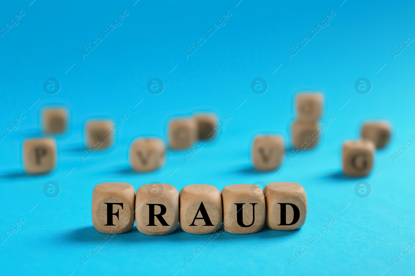 Photo of Word Fraud of wooden cubes with letters on light blue background