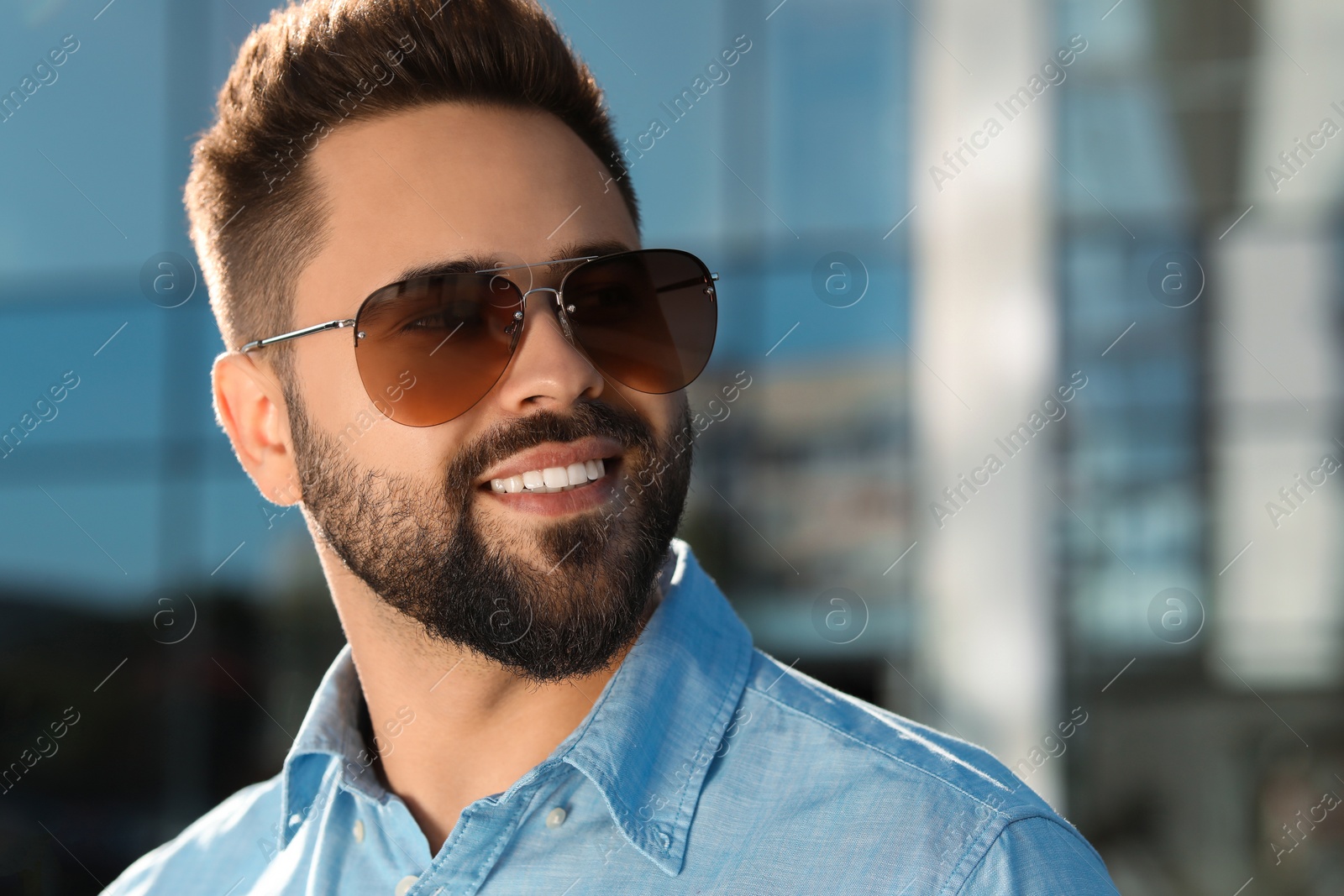 Photo of Handsome smiling man in sunglasses outdoors, space for text