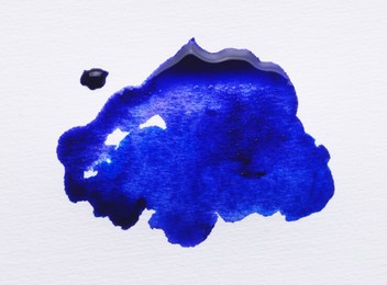 Photo of Blot of blue ink on white background, top view