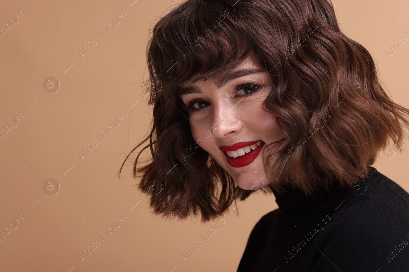 Photo of Portrait of beautiful young woman with wavy hairstyle on beige background. Space for text