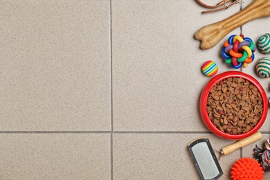 Photo of Bowl with food for cat or dog and accessories on floor. Pet care