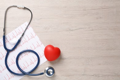 Photo of Stethoscope, cardiogram, red decorative heart and space for text on wooden background, flat lay. Cardiology concept