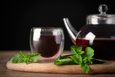 Fresh tea with mint leaves on wooden table