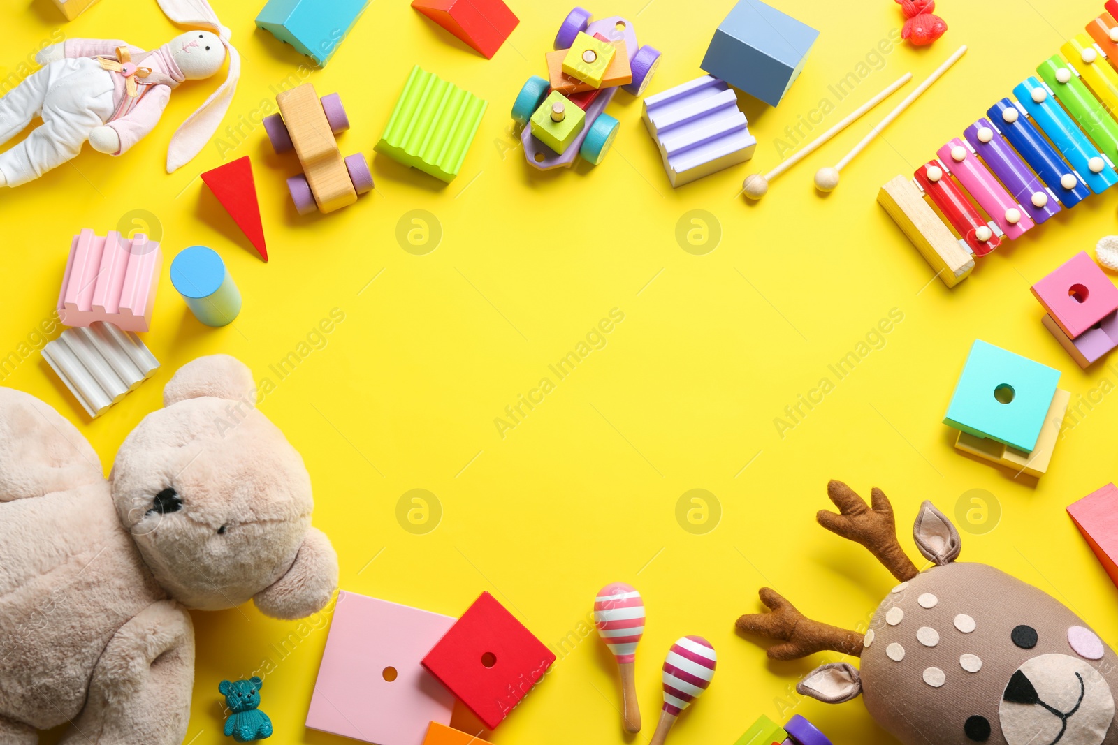 Photo of Frame of different toys on yellow background, flat lay. Space for text