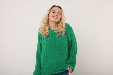 Happy woman in stylish warm sweater on white background