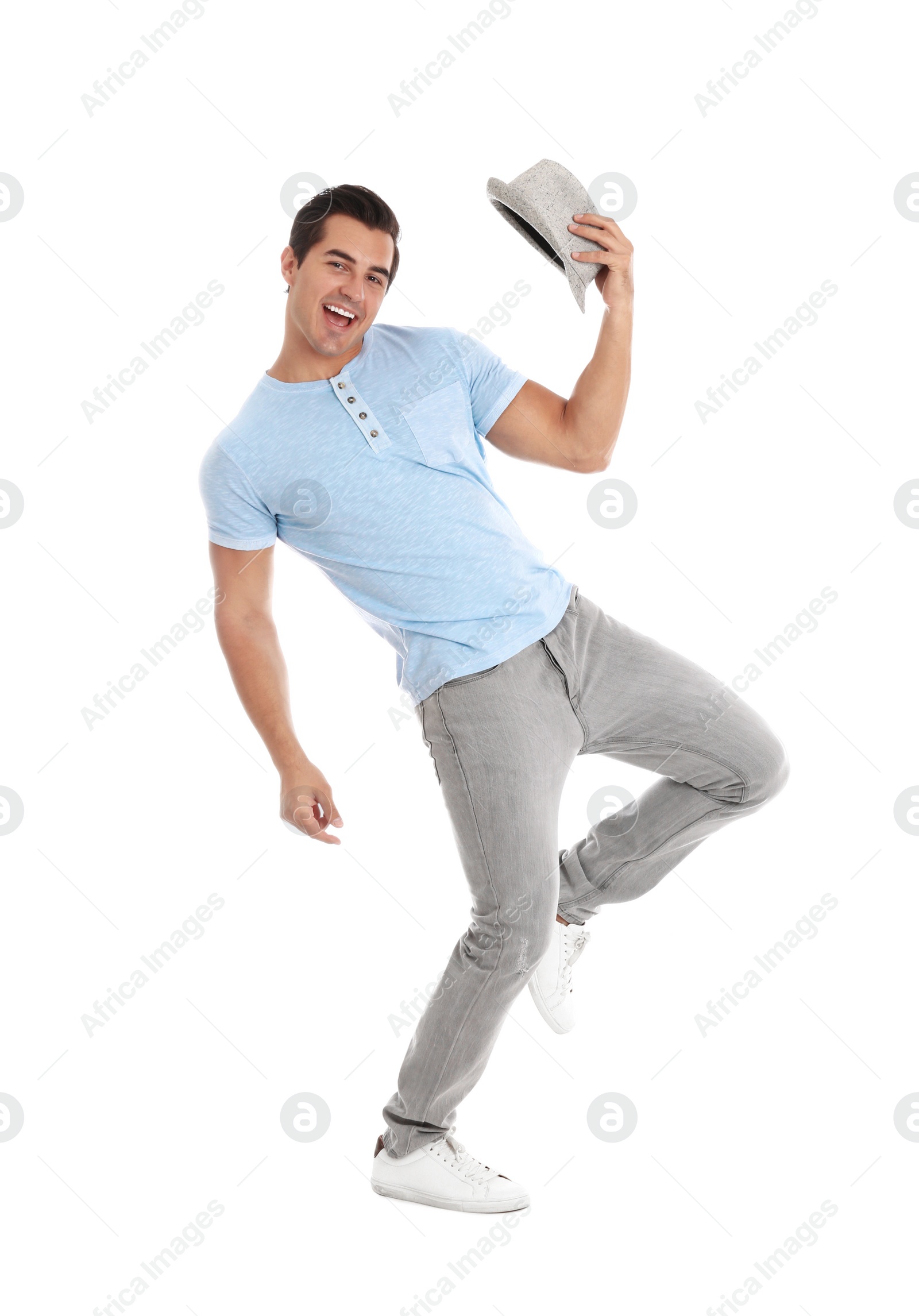 Photo of Handsome young man with hat dancing on white background