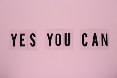 Photo of Phrase Yes You Can of plastic letters on pink background, top view. Motivational quote