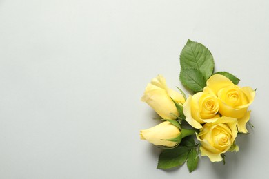 Photo of Beautiful yellow roses on light grey background, flat lay. Space for text