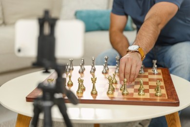 Teacher near chessboard conducting online lesson at home, closeup. Time for hobby