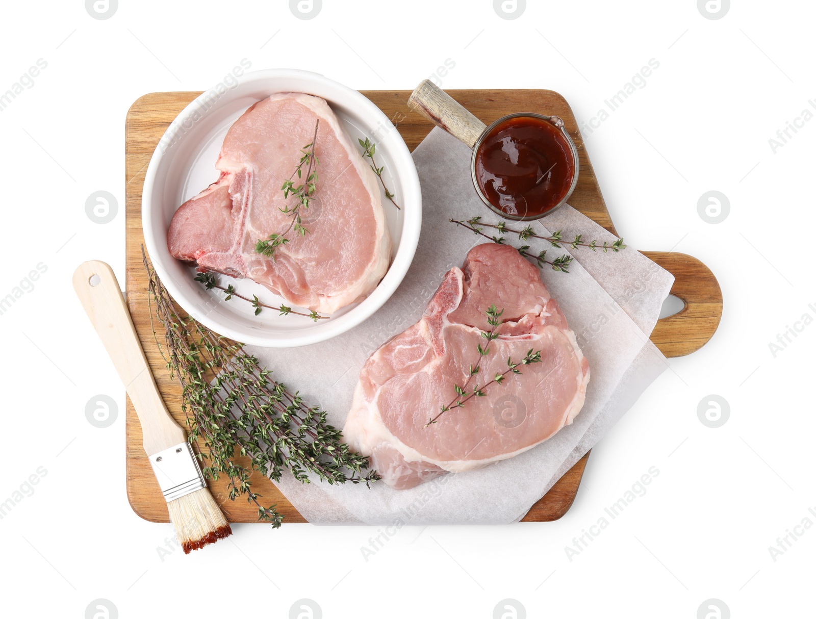Photo of Board with raw meat, thyme, basting brush and marinade isolated on white, top view