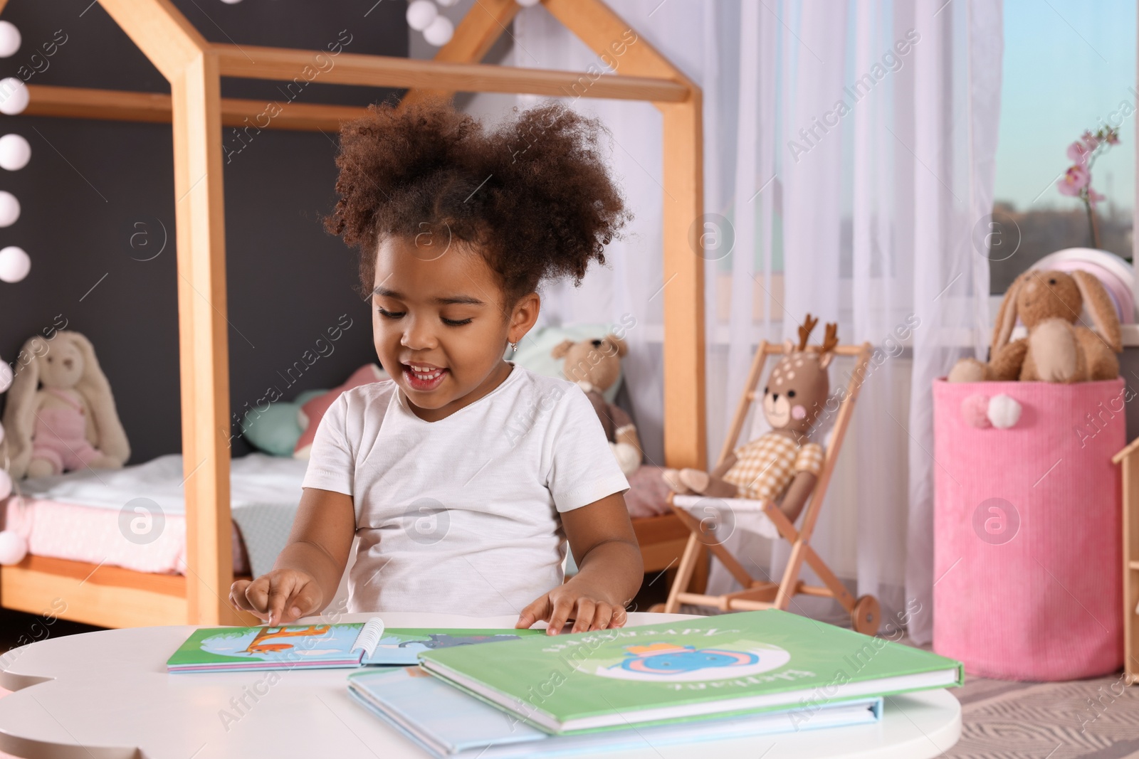 Photo of African American girl reading book at home