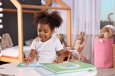 Photo of African American girl reading book at home