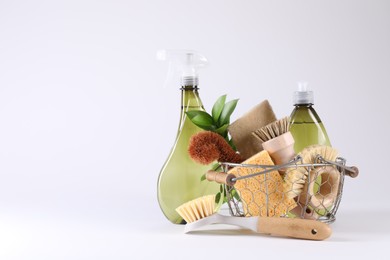 Set of different cleaning supplies in basket on white background