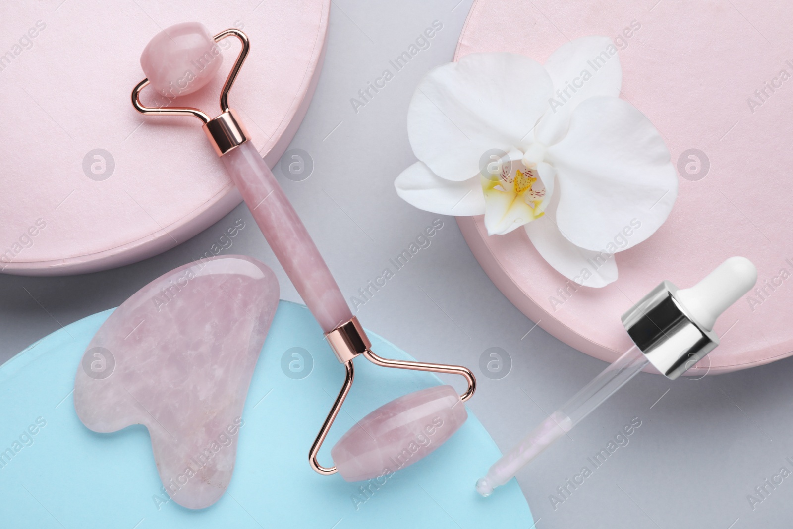 Photo of Flat lay composition with gua sha stone and face roller on color background