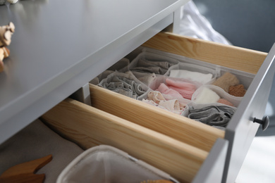 Open cabinet drawer with clothes in child room